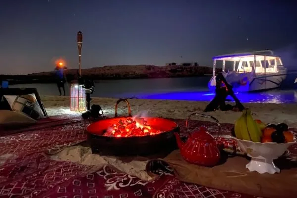 Soirée sur la plage avec feu de camp, bateau et personnes
