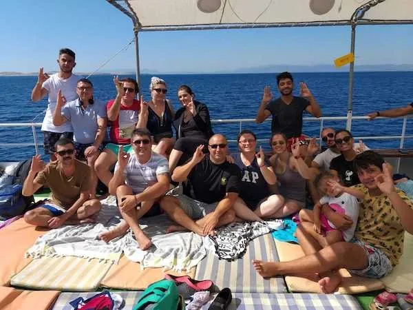 Groupe de personnes souriantes sur le pont d'un bateau en mer