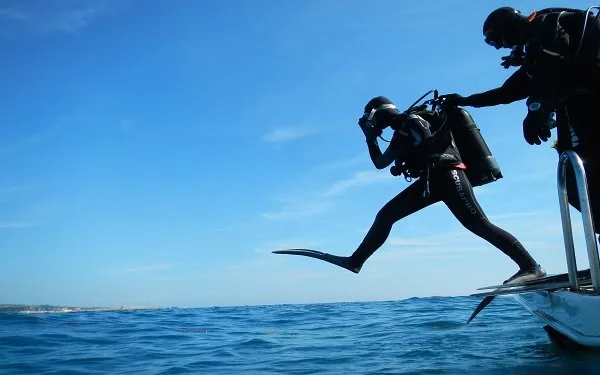 Plongeur s'apprête à entrer dans l'eau depuis un bateau de plongée