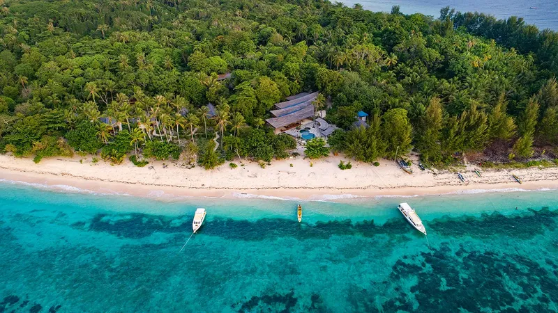 Vue aérienne d'une plage tropicale avec des bateaux et bâtiments