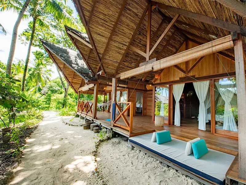 Terrasse en bois d'une structure ouverte sur une plage de sable blanc
