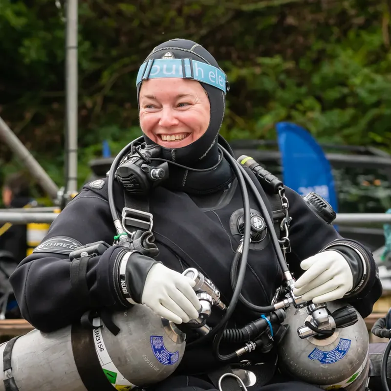 Plongeuse souriante, équipée de son matériel, prête pour une immersion