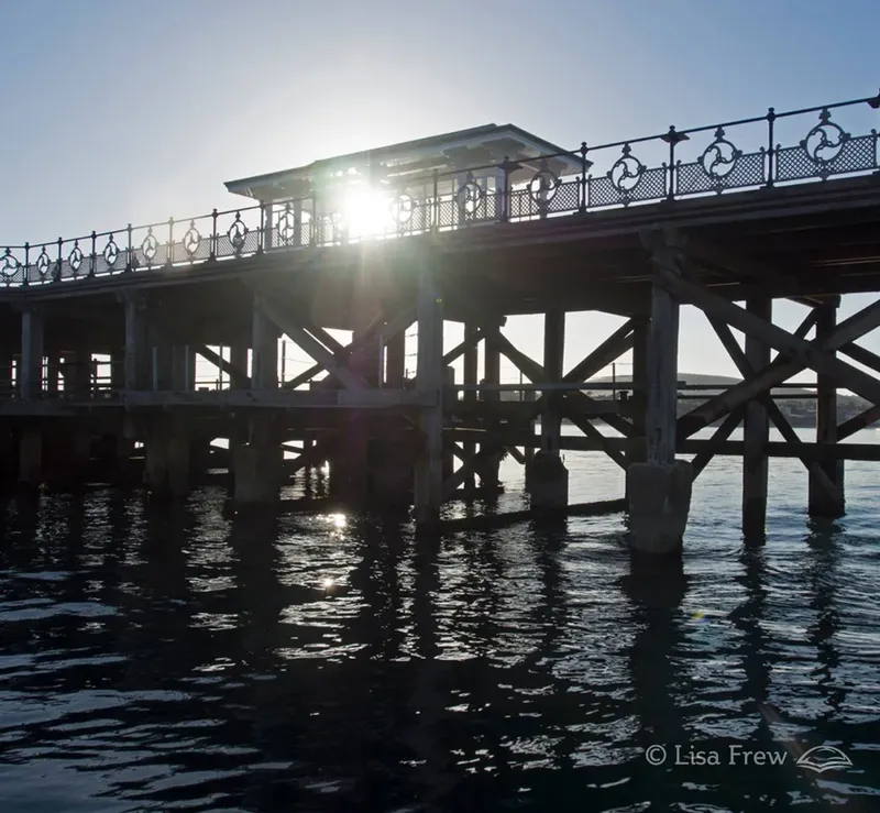 Ponton en bois au-dessus de l'eau, soleil éclatant, reflets lumineux