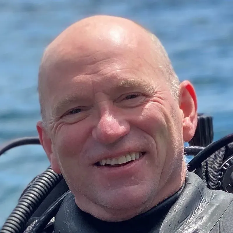 Portrait d'un homme souriant portant une combinaison de plongée noire