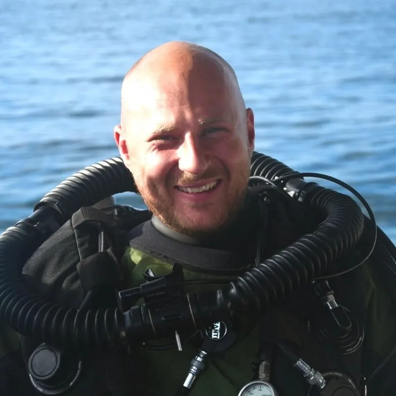 Plongeur souriant avec son équipement complet, prêt pour une immersion