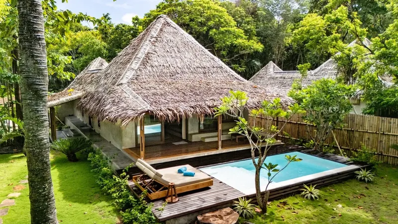 Petites maisons de vacances avec toits de chaume et piscine