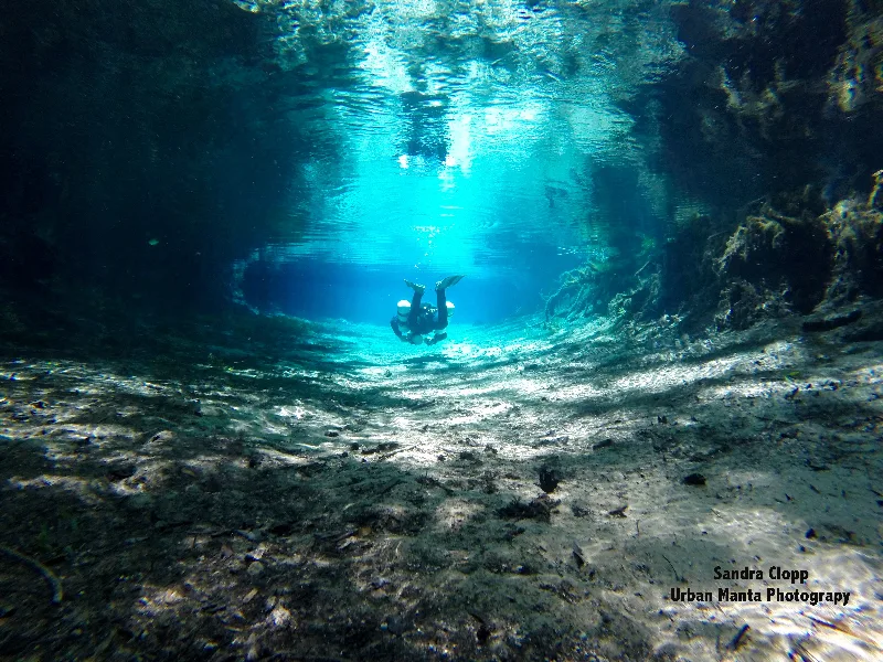 Plongeur en exploration sous-marine dans une grotte éclairée par le soleil