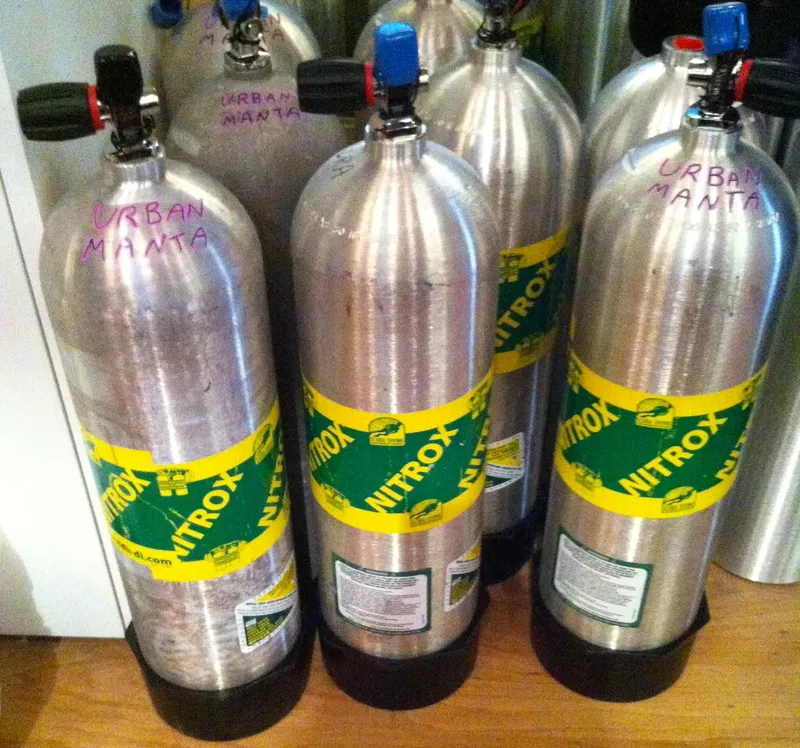 Bouteilles de plongée Nitrox alignées, avec des étiquettes colorées