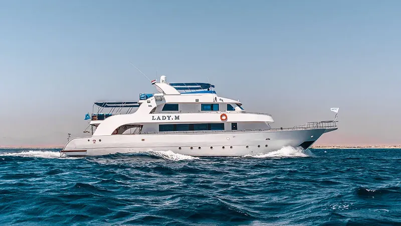 Bateau de plongée blanc naviguant sur une mer bleue calme