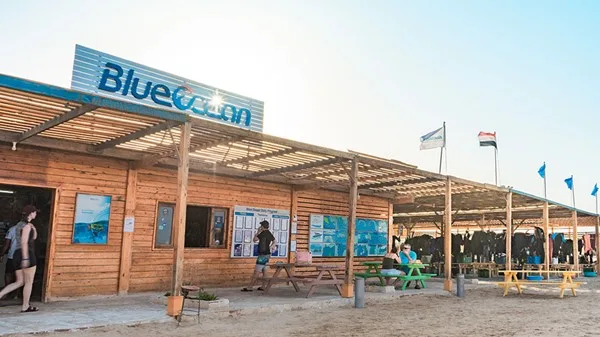 Façade d'un centre de plongée avec des personnes et des drapeaux