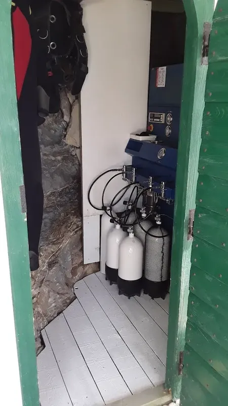 Intérieur d'un local de plongée avec des bouteilles et un compresseur