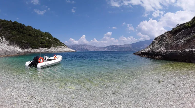 Petit bateau pneumatique échoué sur une plage de galets ensoleillée