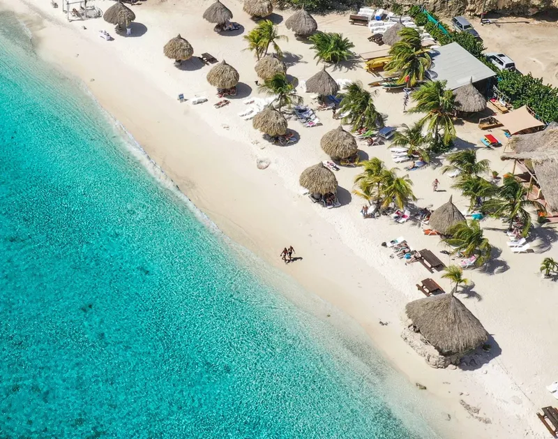 Vue aérienne d'une plage tropicale avec des parasols et des personnes