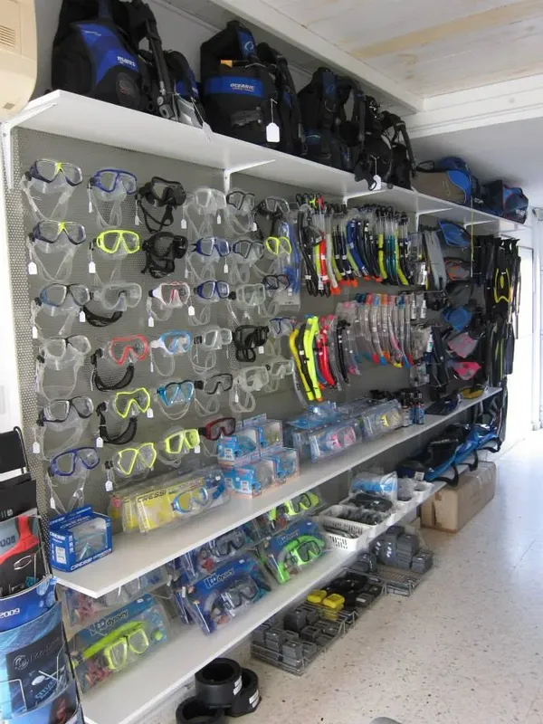 Rayonnages remplis de masques, tubas et accessoires de plongée en magasin