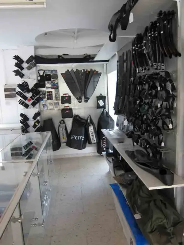 Intérieur d'un magasin de plongée avec des palmes, gilets et combinaisons