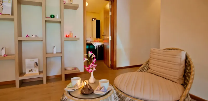 Espace détente intérieur avec fauteuil, étagères et décoration florale