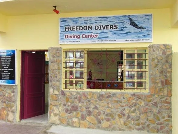 Façade d'un centre de plongée avec une enseigne et une porte rouge