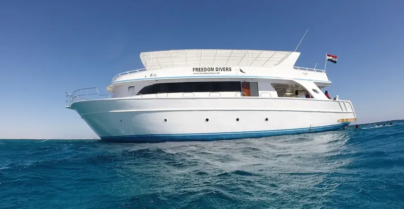 Grand bateau de plongée blanc et bleu sur une mer calme