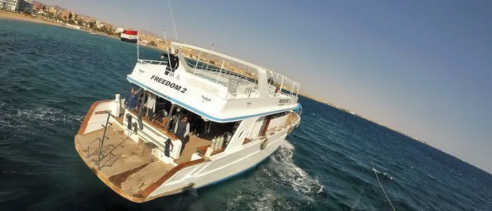 Bateau de plongée blanc avec des passagers et des équipements à bord