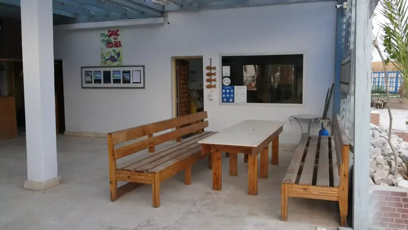 Espace détente extérieur avec tables, bancs et affiches promotionnelles