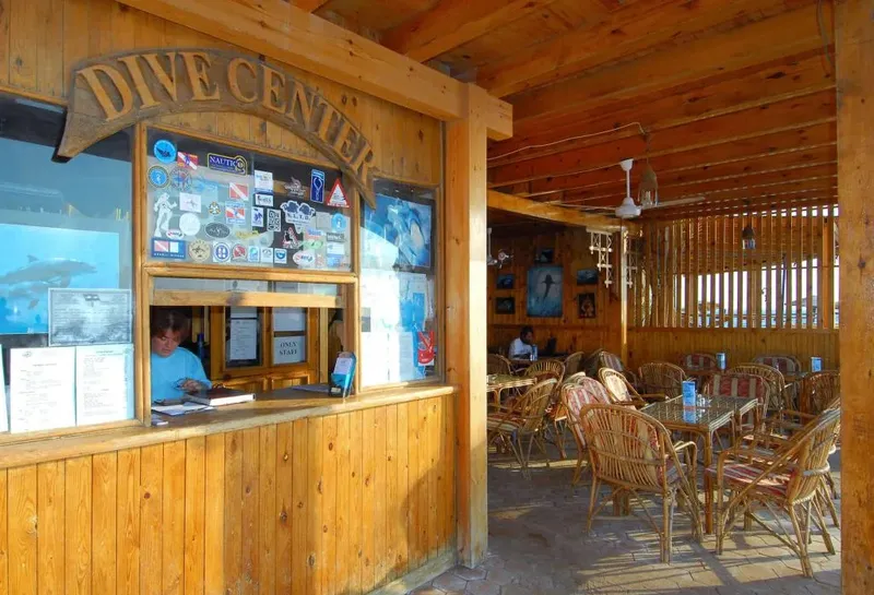 Guichet d'un centre de plongée avec une personne et des tables