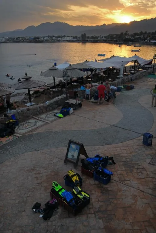 Terrasse de centre de plongée avec matériel, personnes et coucher de soleil