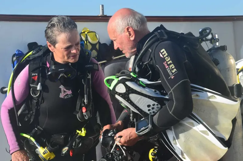 Deux plongeurs en combinaison vérifient l'équipement avant une immersion