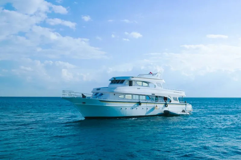Grand bateau de plongée blanc navigue sur une mer bleue calme