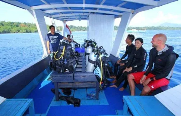Plongeurs préparant leur matériel à bord d'un bateau en mer