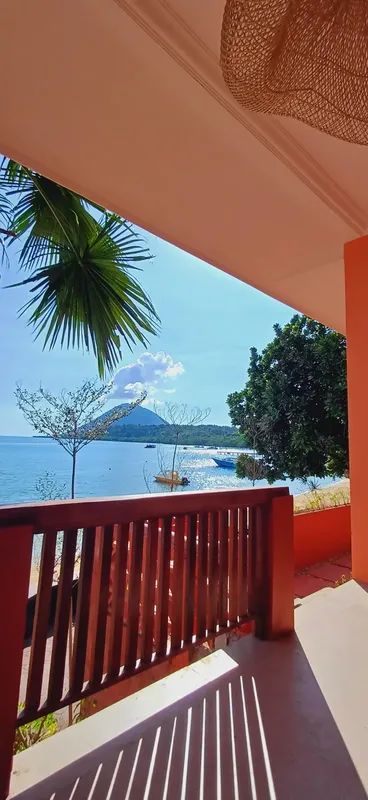 Vue sur la mer, des bateaux et une île depuis une terrasse