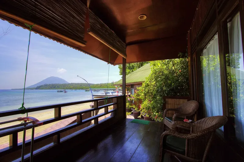 Terrasse en bois avec vue sur mer, montagne et bateaux amarrés