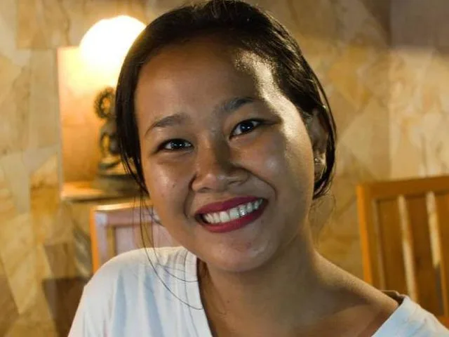 Portrait souriant d'une jeune femme aux cheveux noirs et peau mate