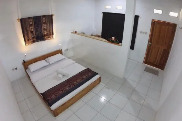 Chambre avec lit double, décoration murale et porte en bois