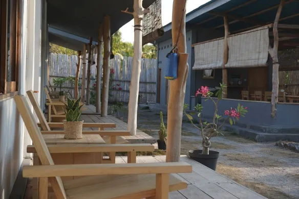 Terrasse en bois avec mobilier, plantes et bâtiments en arrière-plan