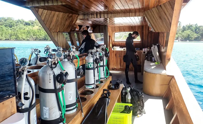 Intérieur d'un bateau de plongée avec des bouteilles et des plongeurs