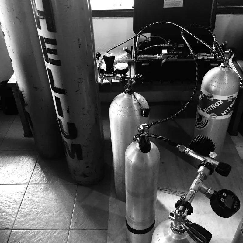 Bouteilles de plongée, détendeurs et compresseur dans un espace de stockage