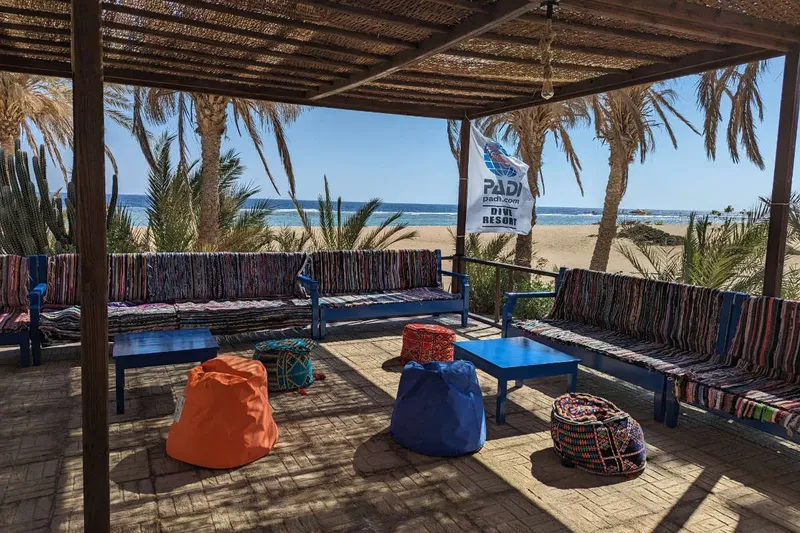 Espace détente extérieur avec canapés, poufs et vue sur la mer