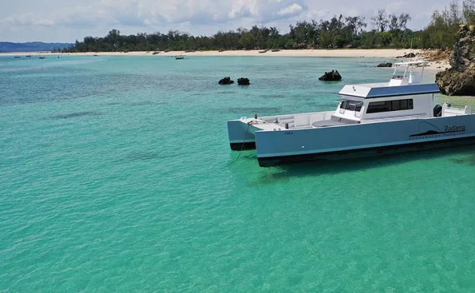 Catamaran bleu turquoise amarré dans une eau claire et peu profonde