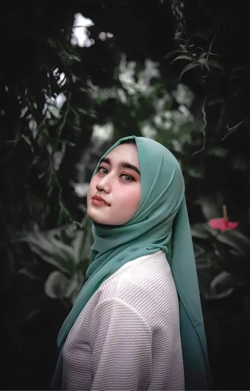 Portrait d'une jeune femme portant un foulard turquoise regardant au loin