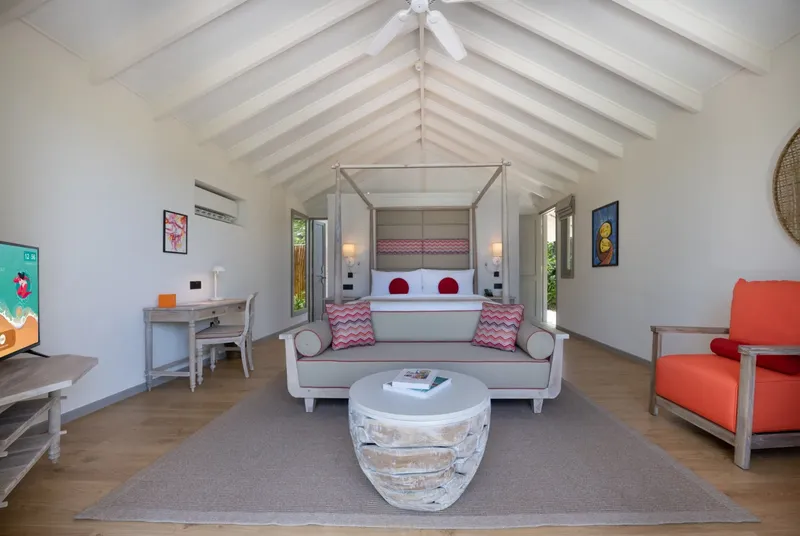 Chambre d'hôtel lumineuse avec lit à baldaquin et décoration tropicale