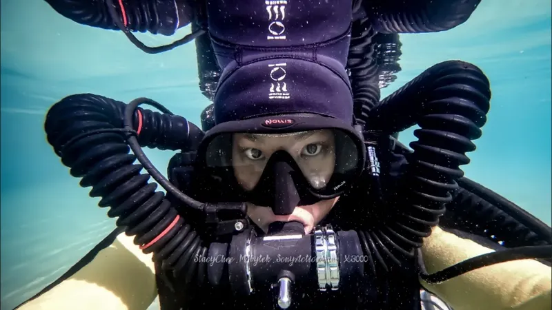 Plongeuse souriante avec masque et équipement complet sous l'eau