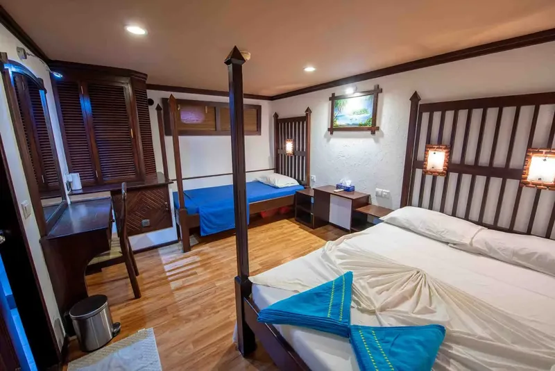 Intérieur d'une cabine de bateau avec lits, bureau et décoration boisée
