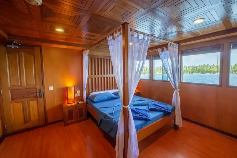 Chambre de bateau avec lit à baldaquin et vue sur mer