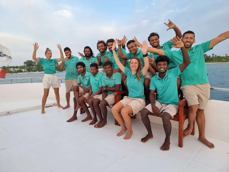 Equipe souriante sur un bateau de plongée en mer calme
