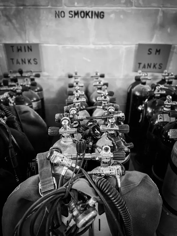 Bouteilles de plongée et détendeurs alignés dans un espace de stockage