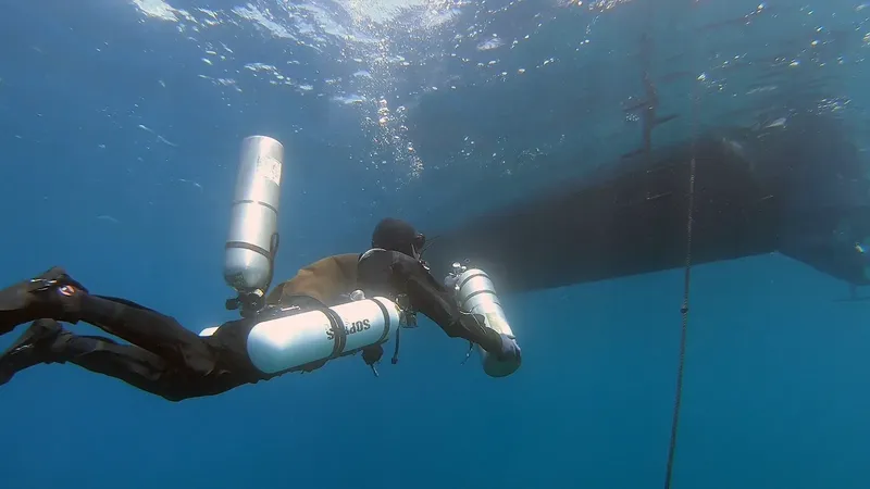 Plongeur en combinaison explore les fonds marins avec deux bouteilles