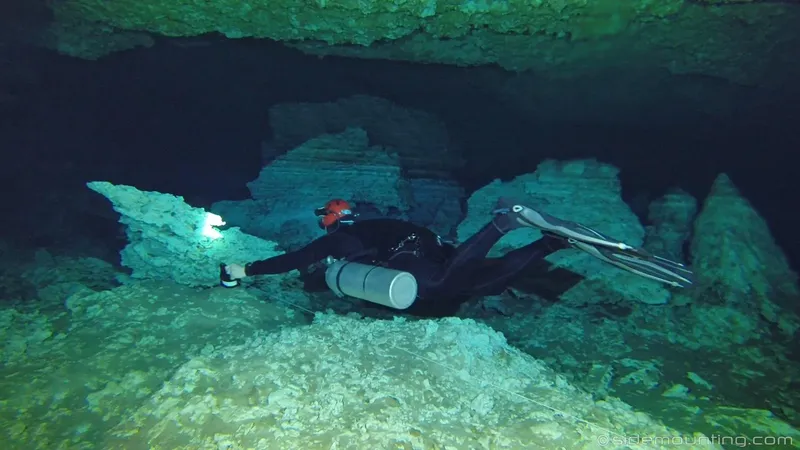 Plongeur explore une grotte sous-marine éclairée par une lampe torche