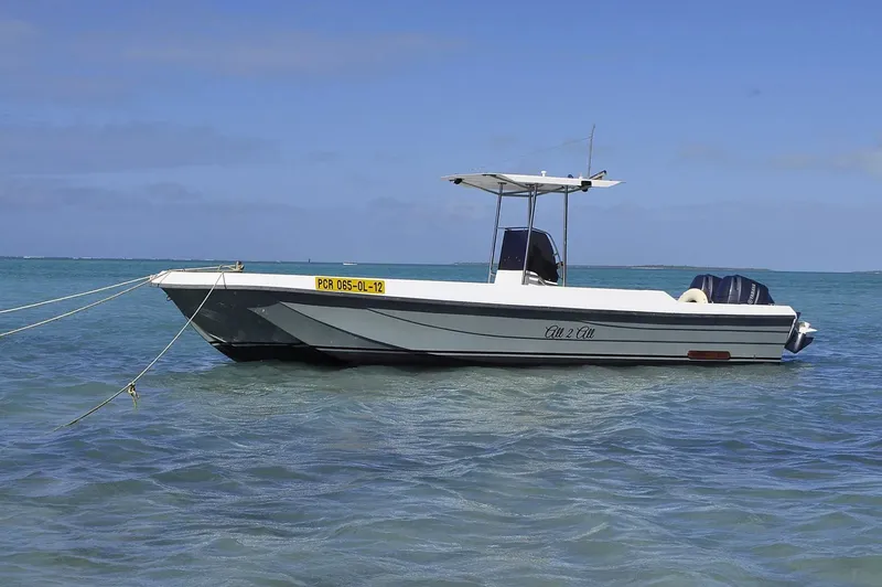 Bateau de plongée amarré dans une eau turquoise sous un ciel bleu