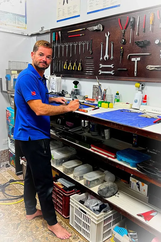 Un technicien de plongée travaille sur du matériel dans un atelier
