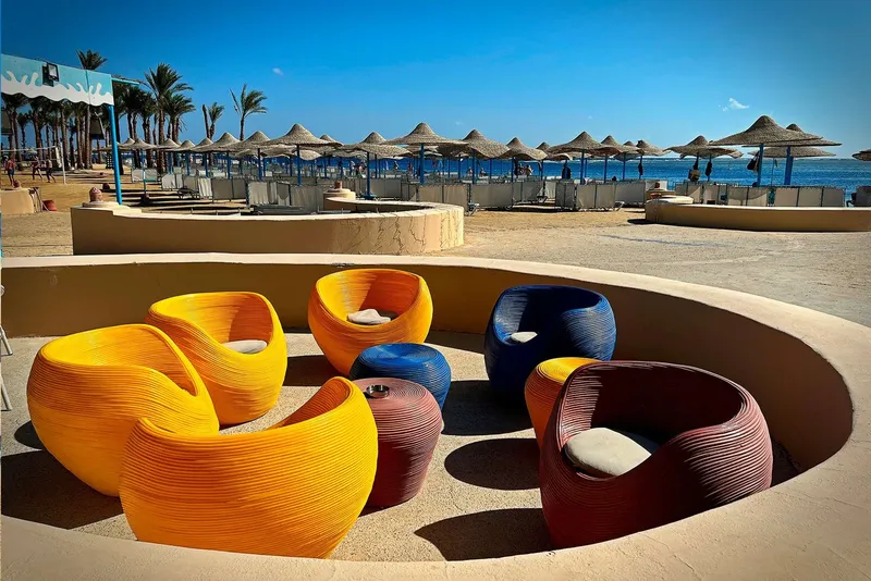 Espace détente avec mobilier coloré face à la mer et parasols